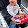 Aaliyah a rejoint le concours — aidez-le/la à gagner de superbes lots ! toddler, child, smiling, toy, piano, playing, adult, outdoor, casual_clothing, jeans, white_shoes, black_jacket, happy, person, seat, chair, daylight, hands, face, expression
