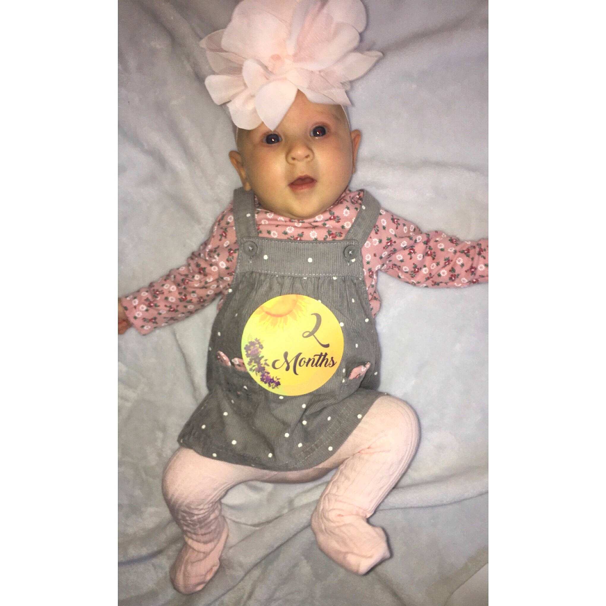 Chevelle is registered to the contest to win money with this photo: baby, baby_products, baby_toddler_clothing, child, doll, dress, eye, font, happy, head, headgear, headwear, human_body, pattern, person, personal_protective_equipment, pink, skin, sleeve, t_shirt