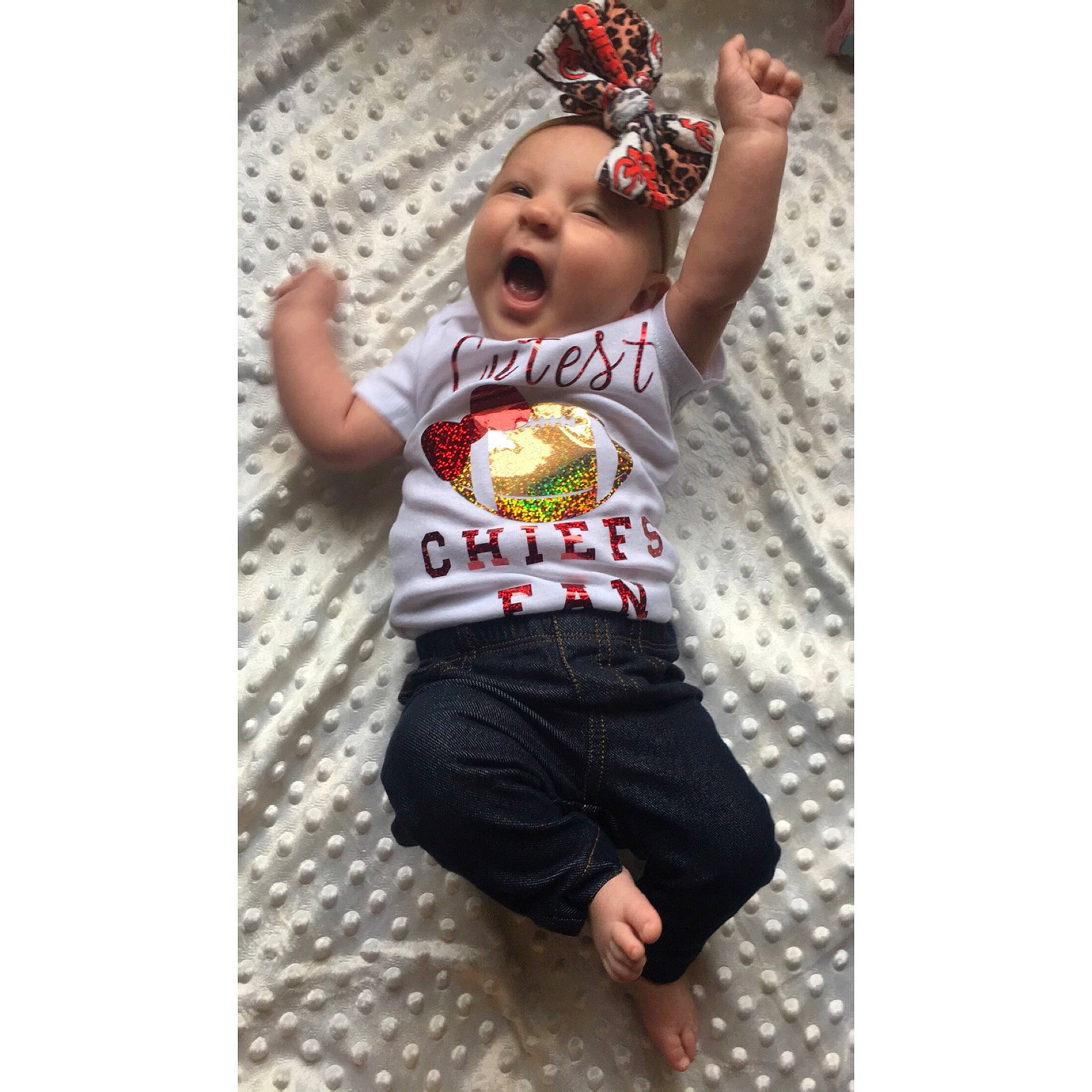 Chevelle is registered to the contest to win money with this photo: arm, baby, baby_toddler_clothing, child, cool, facial_expression, finger, font, gesture, hand, happy, headgear, headwear, jersey, pattern, person, shirt, shorts, sleeve, sportswear