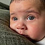 baby, close_up, face, eyes, blanket, soft_texture, curious, infant, skin, portrait, child, resting, indoors, young, expression, cute, head, person, warm_light, cozy