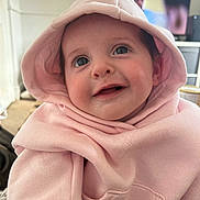 Sienna joined the competition — help win amazing prizes! baby, child, hoodie, pink_clothing, smile, face, cute, portrait, indoors, person, blue_eyes, sweatshirt, happy, infant, young_child, apparel, sitting, cozy, warm, soft_fabric