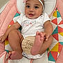 Haylee joined the competition — help win amazing prizes! baby, infant, headband, bow, milestone, wooden_plaque, colorful_cushion, baby_seat, smiling, happy, cute, feet, legs, onesie, child, portrait, indoors, playful, young, person