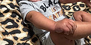 Haylee is registered to the contest to win money with this photo: baby, smiling, infant, onesie, grey_clothing, leopard_print, blanket, happy, cute, child, skin, face, lying_down, small_hands, small_feet, indoors, infant_clothing, cheerful, person, portrait