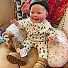 Gretchen is registered to the contest to win money with this photo: baby, blanket, cap, clothing, couch, cushion, face, furniture, happy, hat, head, homedecor, pants, person, photography, portrait, sitting, smile, text, toy