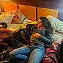 Blackboi is registered to the contest to win money with this photo: woman, dog, bed, pillow, blanket, jeans, sweater, resting, snuggling, indoor, relaxed, black_dog, harness, casual_clothing, headboard, hand, long_hair, comfort, sleeping, warm_light