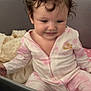 Diana a rejoint le concours — aidez-le/la à gagner de superbes lots ! toddler, child, baby, onesie, pink_clothing, crib, blanket, curly_hair, smile, indoors, soft_lighting, cozy, infant, sitting, face, person, cute, home, sleepwear, resting
