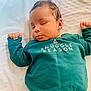 baby, blanket, casual_clothing, child, closed_eyes, cozy, cute, cute_expression, green_sweater, hands_up, indoors, infant, peaceful, portrait, relaxation, resting, sleeping, snuggle_season, soft_texture, young_child