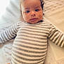 Zayne is registered to the contest to win money with this photo: baby, infant, child, striped_onesie, curly_hair, lying_down, blanket, soft_texture, cute, portrait, indoors, young, person, skin, face, expression, wide_eyes, calm, closeup, cozy