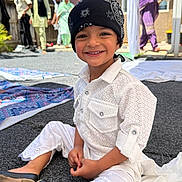 Shiva joined the competition — help win amazing prizes! child, smile, bandana, white_outfit, sitting, carpet, outdoor, people, adults, background, portrait, happy, shoes, festival, gathering, traditional_clothing, headwear, yard, sunlight, family