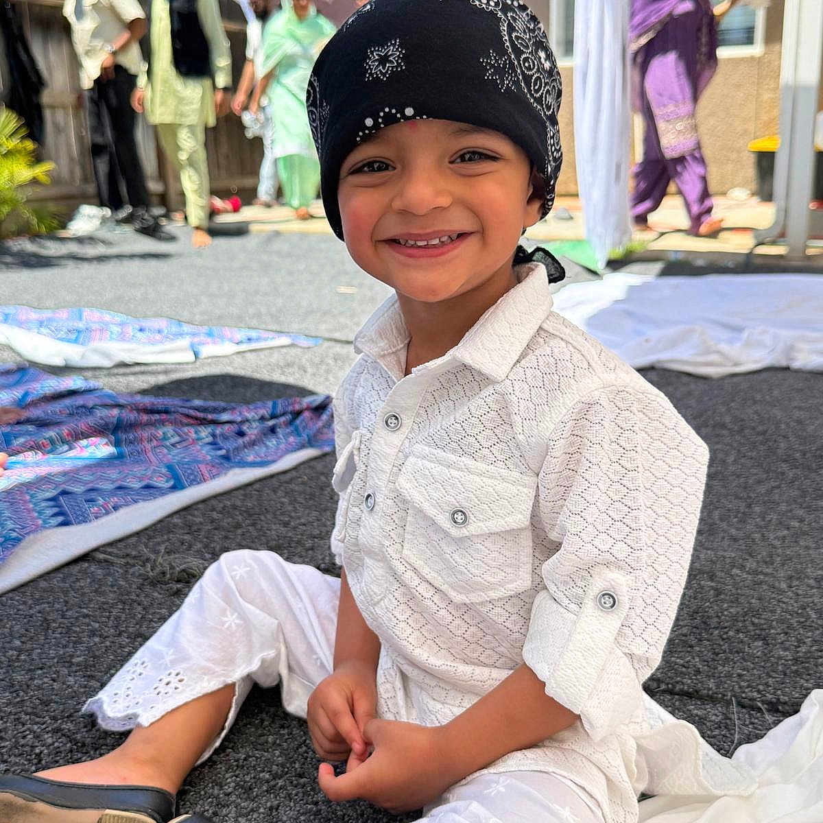 Shiva joined the competition — help win amazing prizes! adults, background, bandana, carpet, child, family, festival, gathering, happy, headwear, outdoor, people, portrait, shoes, sitting, smile, sunlight, traditional_clothing, white_outfit, yard