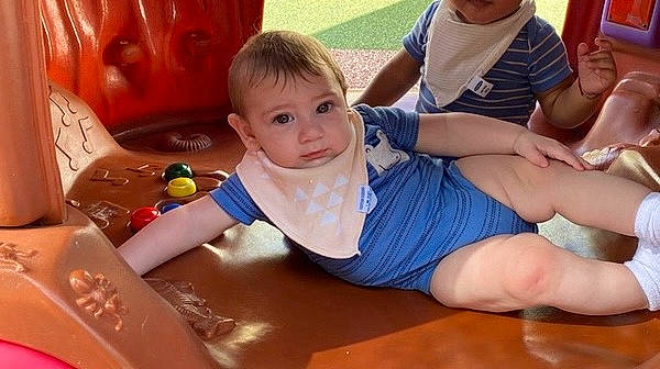 Meliodas is registered to the contest to win money with this photo: baby, barefoot, chair, child, event, flooring, foot, fun, happy, knee, lap, leisure, person, play, recreation, room, shorts, sitting, t_shirt, thigh