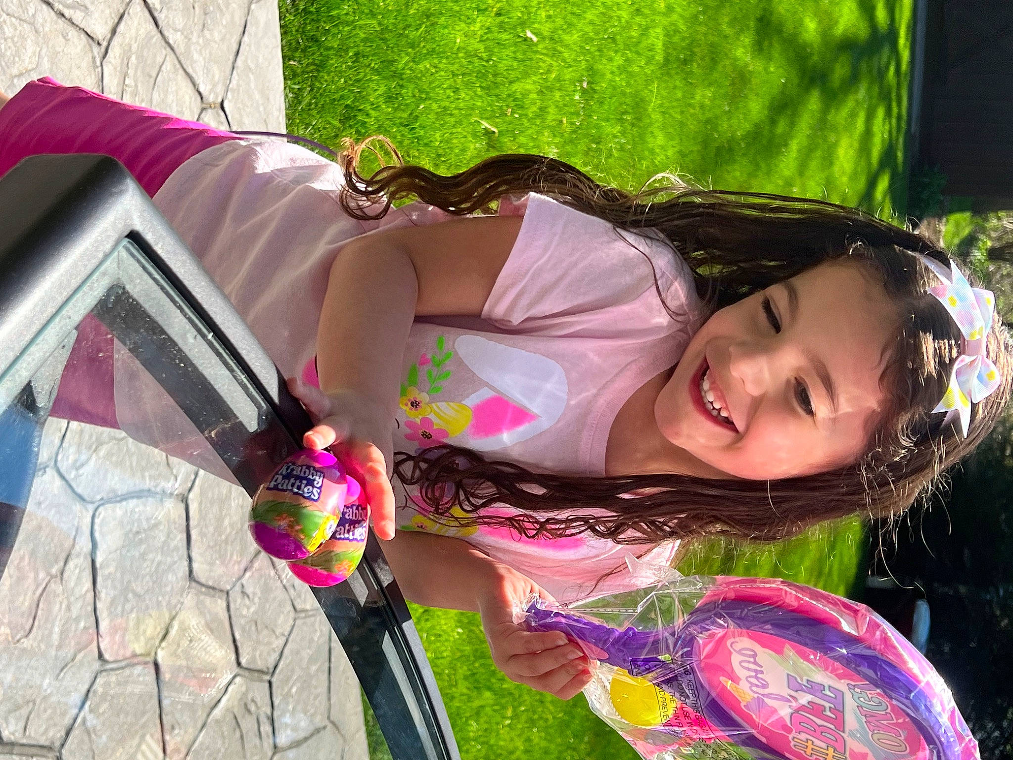 Tiana is registered to the contest to win money with this photo: child, dress, eyewear, fashion_accessory, fun, grass, green, happy, joy, leisure, magenta, people_in_nature, person, pink, recreation, smile, tree, window