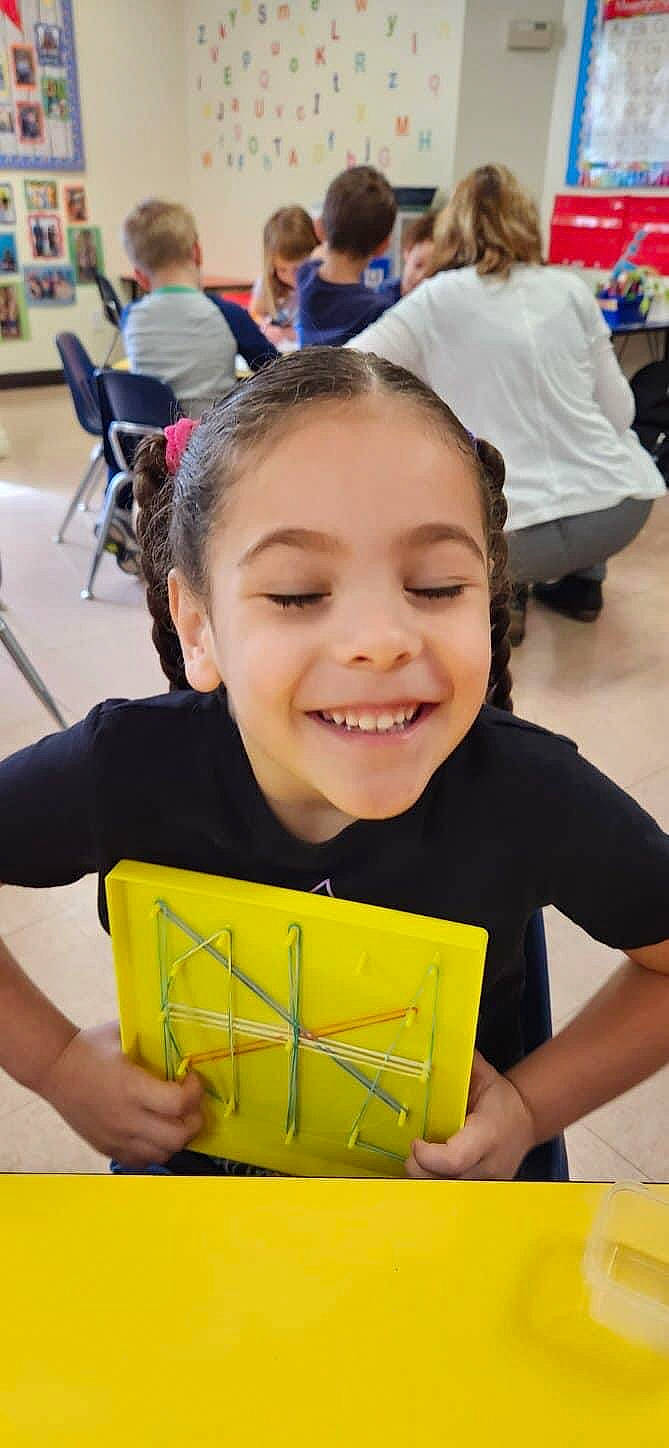 Tiana is registered to the contest to win money with this photo: chair, child, event, font, fun, happy, joy, learning, leisure, person, photograph, photography, play, recreation, room, school, smile, snapshot, t_shirt, toddler