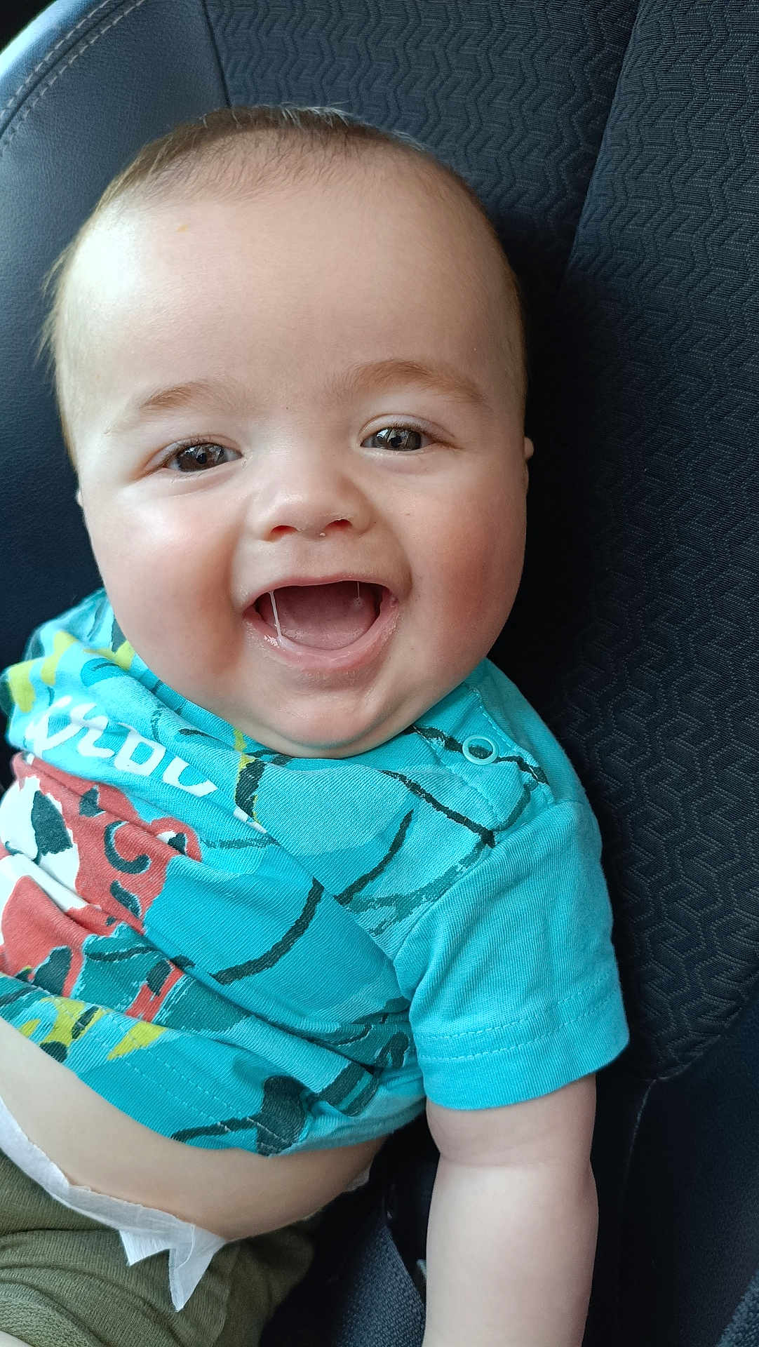 Nélyo participe au concours pour gagner de l'argent avec cette photo : baby, smiling, child, car_seat, turquoise_shirt, happy, face, infant, clothing, person, portrait, seat, cute, young_child, skin, head, sitting, casual, close_up, cheerful