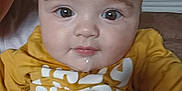 Nélyo participe au concours pour gagner de l'argent avec cette photo : baby, child, drool, face, eyes, glasses, home, indoor, mustard_shirt, person, portrait, sitting, toddler, white_text, yellow_clothing, closeup, couch, adult, partial_face, casual