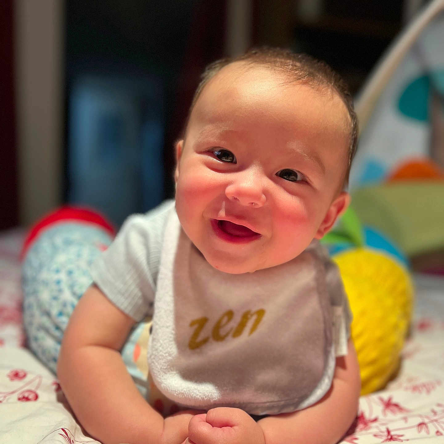 Gabriel a rejoint le concours — aidez-le/la à gagner de superbes lots ! baby, bedspread, bib, child, closeup, clothing, cute, face, hands, happy, home, indoor, infant, lying_down, pattern, person, portrait, smiling, soft_focus, zen