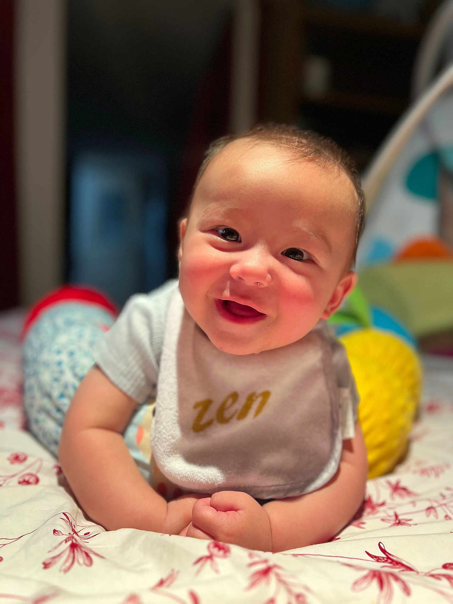 Gabriel a rejoint le concours — aidez-le/la à gagner de superbes lots ! baby, bedspread, bib, child, closeup, clothing, cute, face, hands, happy, home, indoor, infant, lying_down, pattern, person, portrait, smiling, soft_focus, zen