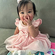 Scarlett joined the competition — help win amazing prizes! baby, child, pink_dress, white_tights, bow, smile, couch, blanket, indoor, cute, pearl_necklace, happy, sitting, girl, hand, face, hair_bow, soft_lighting, portrait, infant