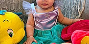 Scarlett joined the competition — help win amazing prizes! baby, child, colorful, couch, cute, decorative_net, happy, headband, indoor, mermaid_costume, milestone_card, plush_toy, portrait, seashell, sitting, smiling, soft_toys, starfish, toddler, young_child