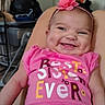 baby, smile, pink_shirt, headband, flower, indoor, person, child, happy, clothing, sitting, cute, face, infant, apparel, cheerful, skin, expression, young, portrait