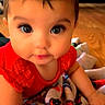 baby, child, infant, red_clothing, blanket, indoor, floor, wood_floor, curious, closeup, face, big_eyes, cute, toddler, crawling, colorful_blanket, soft_lighting, portrait, person, home