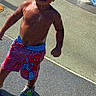 toddler, child, water, splash_pad, outdoor, sunny, swim_trunks, spiderman, crocs, bare_chest, wet_skin, playground, walking, water_droplets, summer, young_child, curly_hair, active, fun, daytime