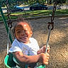 King is registered to the contest to win money with this photo: baby, chains, child, clothing, daytime, fence, fun, green, happy, joy, outdoor, park, person, playground, smile, sunlight, swing, toddler, trees, woodchips