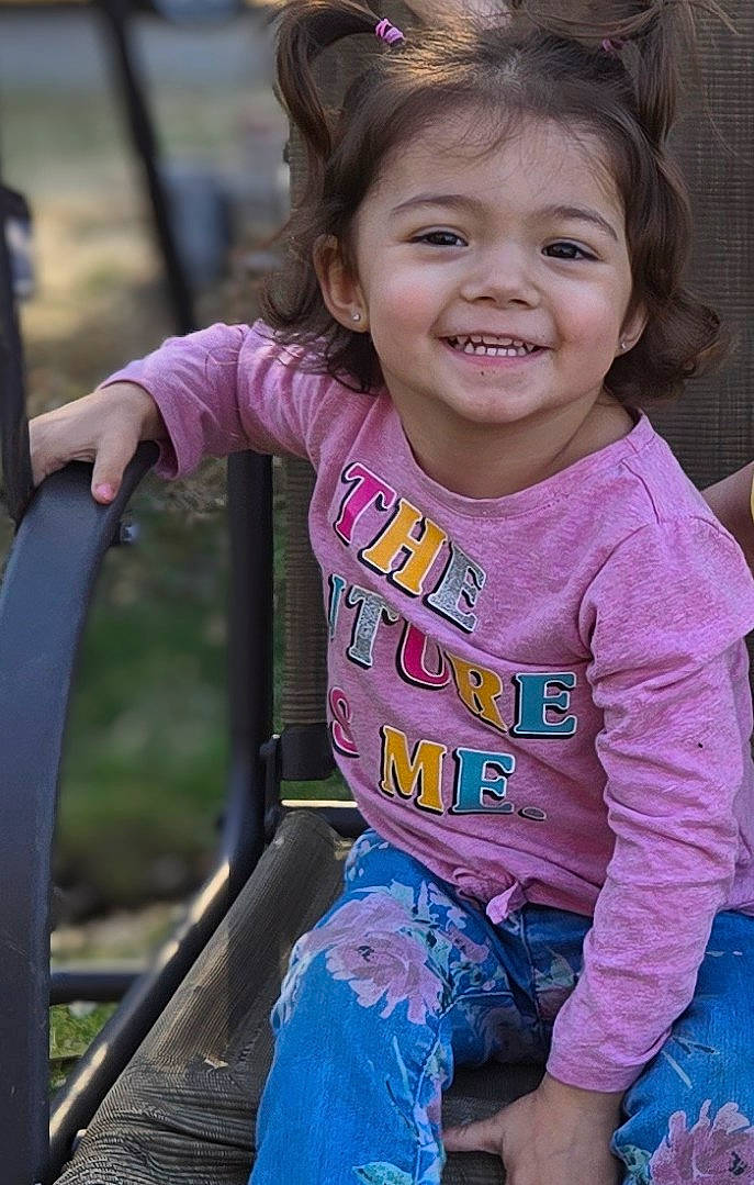 Saylor joined the competition — help win amazing prizes! bodypart, child, clothing, face, female, girl, grass, happy, head, jeans, mouth, pants, person, photography, plant, portrait, sitting, smile, t_shirt, teeth