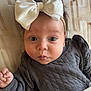 baby, infant, child, face, headband, bow, clothing, blanket, expression, cute, wide_eyes, pout, skin, hand, lying_down, indoor, portrait, soft, warm, cozy