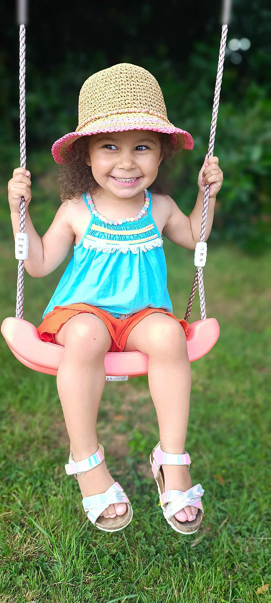 Avah participe au concours pour gagner de l'argent avec cette photo : child, girl, swing, outdoor, grass, hat, smile, happy, summer, play, toy, footwear, sandals, greenery, cute, portrait, sunlight, rope, colorful_clothing, nature