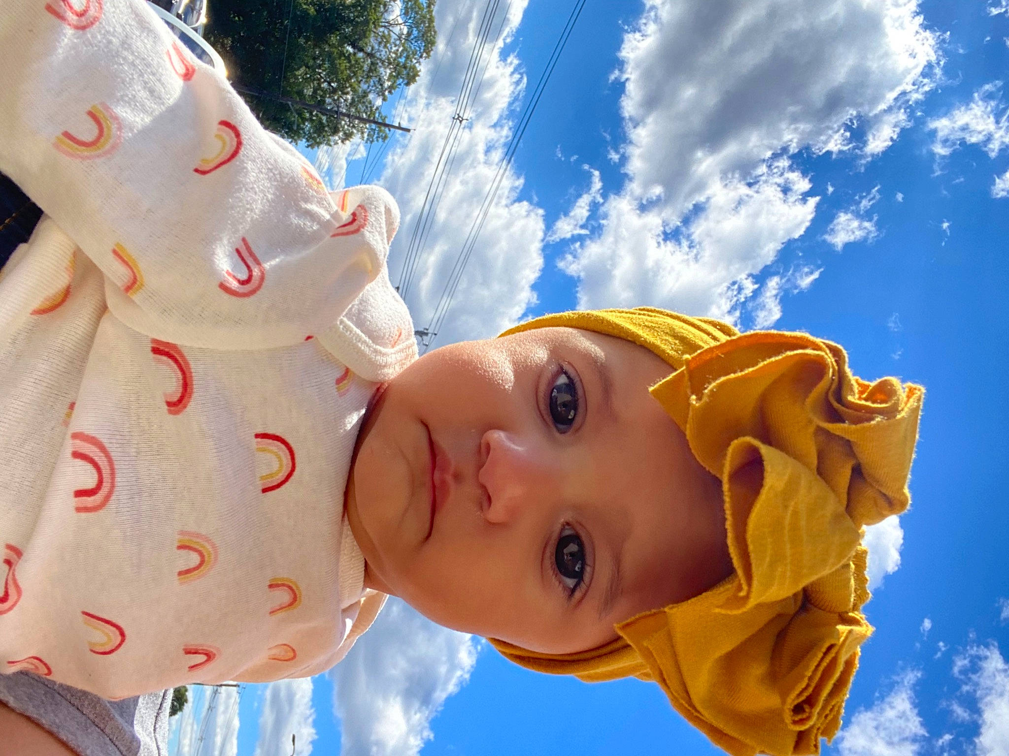 Iris is registered to the contest to win money with this photo: art, baby, blue, cloud, cumulus, electric_blue, eye, fun, gesture, happy, headwear, leisure, meteorological_phenomenon, nose, people_in_nature, person, skin, sky, sunlight, toddler