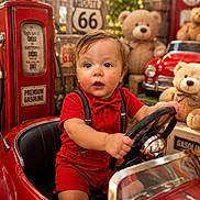 Alexandro joined the competition — help win amazing prizes! bow_tie, child, cute, daylight, face, nostalgic, outdoor, playful, portrait, red_clothing, red_toy_car, retro, route_66_sign, sitting, smiling, steering_wheel, teddy_bear, toddler, toy_car, vintage_gas_pump