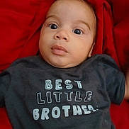 Erick joined the competition — help win amazing prizes! baby, child, chubby_cheeks, clothing, curious, cute, expression, face, indoors, infant, laying_down, person, portrait, red_blanket, sitting, soft_lighting, text, tshirt, wide_eyes, young_child