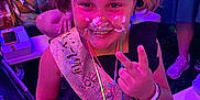 Amaryllis joined the competition — help win amazing prizes! child, girl, party, cake, face_paint, sash, smile, peace_sign, glowing_necklaces, pigtails, celebration, indoor, happy, person, event, colorful, fun, people, table, food
