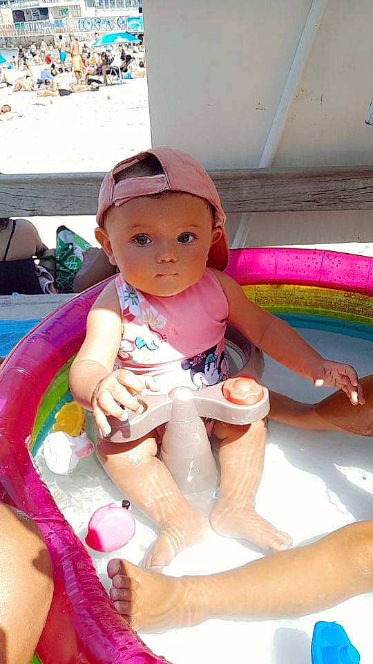Alyah participe au concours pour gagner de l'argent avec cette photo : baby, baby_toddler_clothing, bathing, cap, child, fun, happy, headwear, human_leg, knee, lap, leisure, magenta, person, pink, play, shorts, sitting, skin, thigh