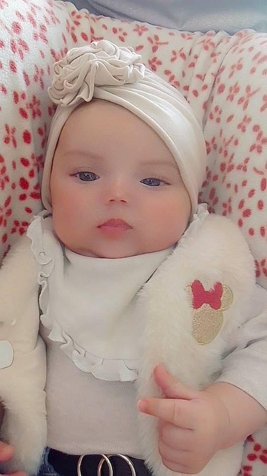 Alyah participe au concours pour gagner de l'argent avec cette photo : baby, baby_toddler_clothing, cap, cheek, child, chin, comfort, eye, eyelash, fashion_accessory, happy, hat, head, headwear, lip, person, pink, skin, sleeve, textile