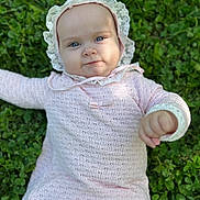 Millie is registered to the contest to win money with this photo: baby, bonnet, cap, clothing, coat, dress, face, grass, hat, head, hood, knitwear, longsleeve, person, photography, plant, portrait, sleeve, sunhat, sweater