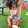 adult, barefoot, bracelets, bull, child, cute, denim_shorts, fun, girl, grass, hair_clip, minnie_mouse, outdoor, play, playground, smiling, summer, support, tank_top, toy