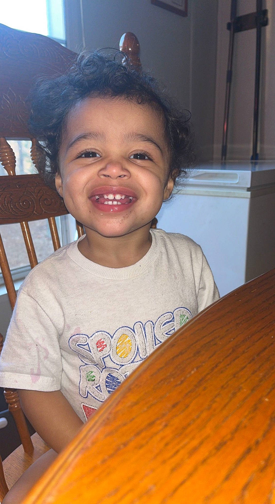 Addison is registered to the contest to win money with this photo: chair, cheek, chin, eye, eyebrow, forehead, fun, hairstyle, happy, iris, joy, mouth, nose, organ, person, skin, smile, standing, t_shirt, toddler