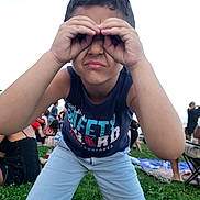 Aylan participe au concours pour gagner de l'argent avec cette photo : blue_shirt, boy, casual_clothing, child, crowd, daylight, event, fun, gesture, grass, happy, leisure, light_pants, nature, outdoor, people, picnic, playing, summer, young
