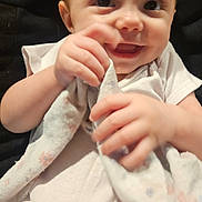 Ryett is registered to the contest to win money with this photo: baby, infant, smiling, blanket, white_clothing, hands, face, eyes, mouth, skin, cute, happy, closeup, portrait, child, young, soft_texture, cozy, indoors, sitting
