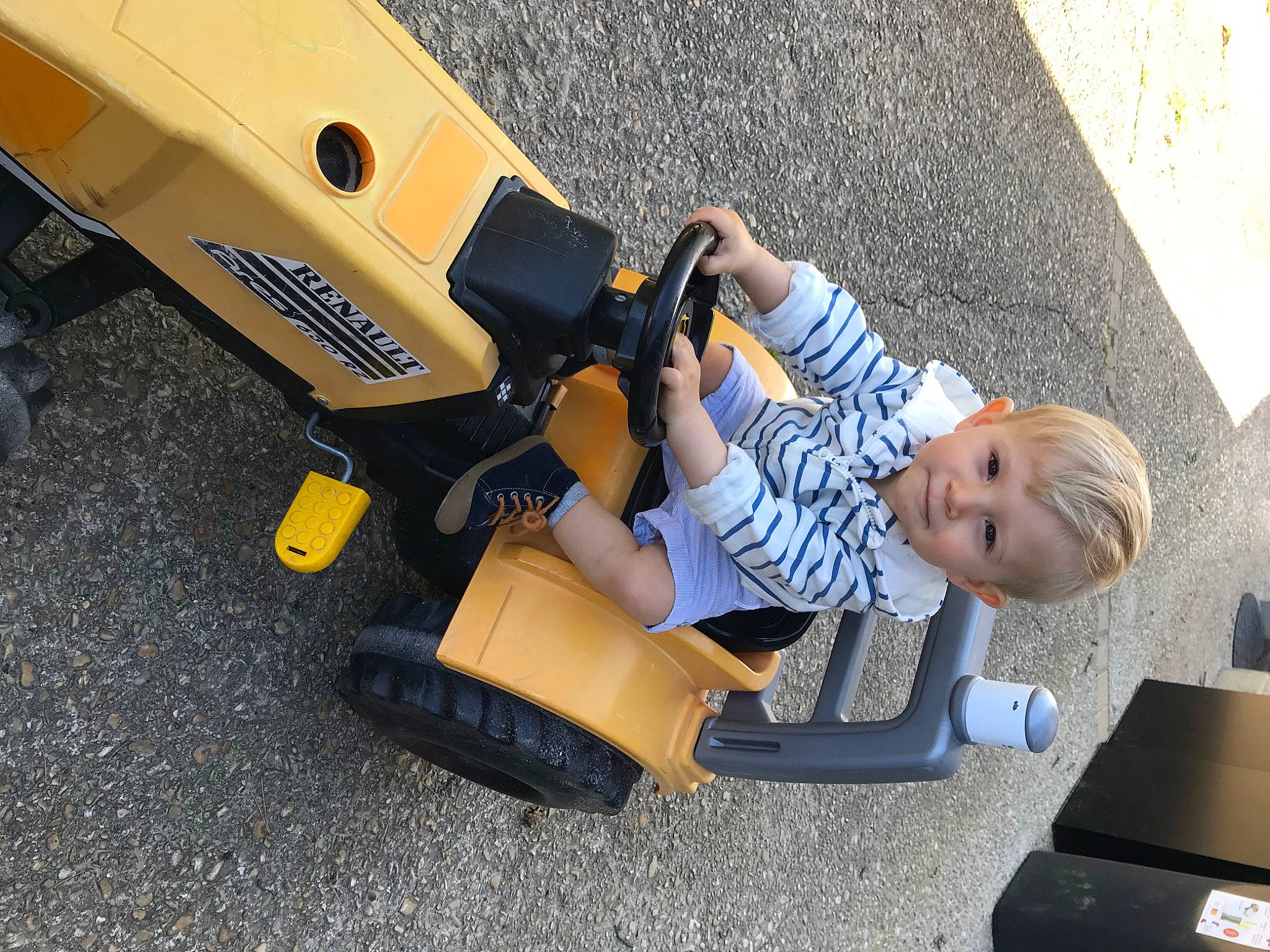 Anatole participe au concours pour gagner de l'argent avec cette photo : asphalt, auto_part, automotive_design, automotive_exterior, automotive_tire, automotive_wheel_system, bumper, child, flooring, fun, human_leg, leg, motor_vehicle, person, personal_protective_equipment, recreation, smile, tire, toddler, vehicle