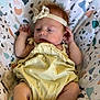 baby, infant, child, yellow_outfit, headband, floral_headband, patterned_seat, colorful_background, barefoot, small_hands, small_feet, relaxed, indoors, portrait, cute, young, sitting, comfortable, soft_lighting, skin