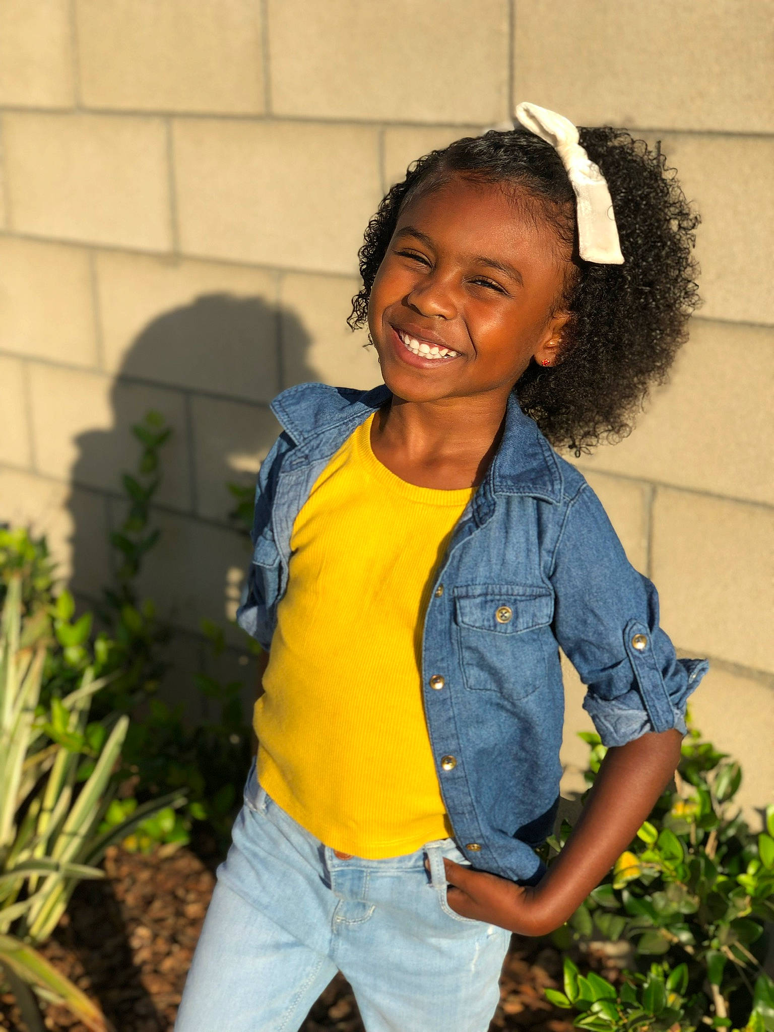 Casey is registered to the contest to win money with this photo: adaptation, black_hair, child, denim, facial_expression, fun, hairstyle, happy, jeans, joy, long_hair, person, photo_shoot, photography, plant, smile, t_shirt, textile