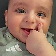 Ali joined the competition — help win amazing prizes! baby, child, face, smile, hand, thumb, eyes, cute, infant, portrait, clothing, green_shirt, skin, expression, person, closeup, happy, young, indoors, head