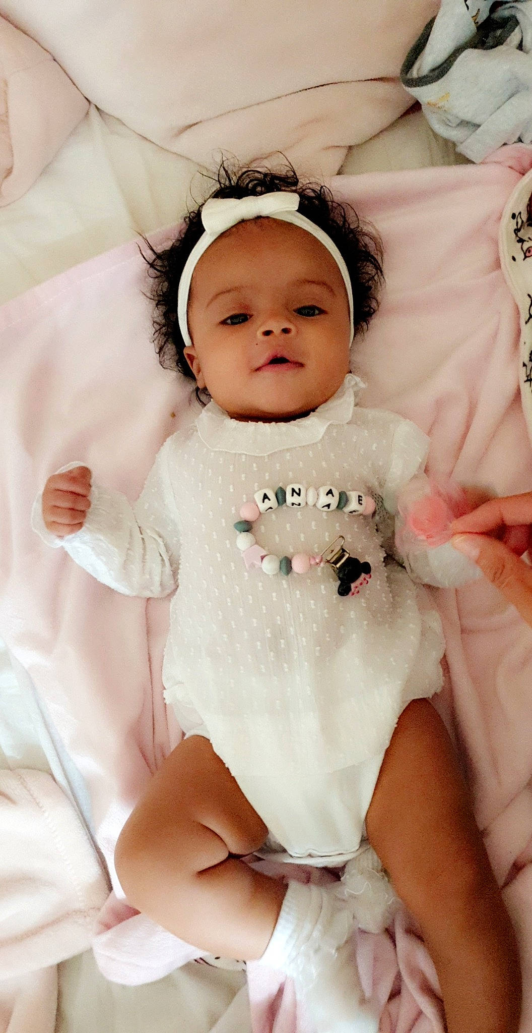 Anaë a rejoint le concours — aidez-le/la à gagner de superbes lots ! baby, baby_products, baby_toddler_clothing, cheek, child, doll, hair_accessory, head, headband, headpiece, person, pink, product, skin, smile, toddler, white