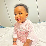 Francesca Gisèle a rejoint le concours — aidez-le/la à gagner de superbes lots ! baby, child, pink_pajamas, smiling, sitting, bed, white_bedspread, indoor, curly_hair, cute, happy, infant, portrait, toddler, person, face, cozy, soft_lighting, clothing, sleepwear