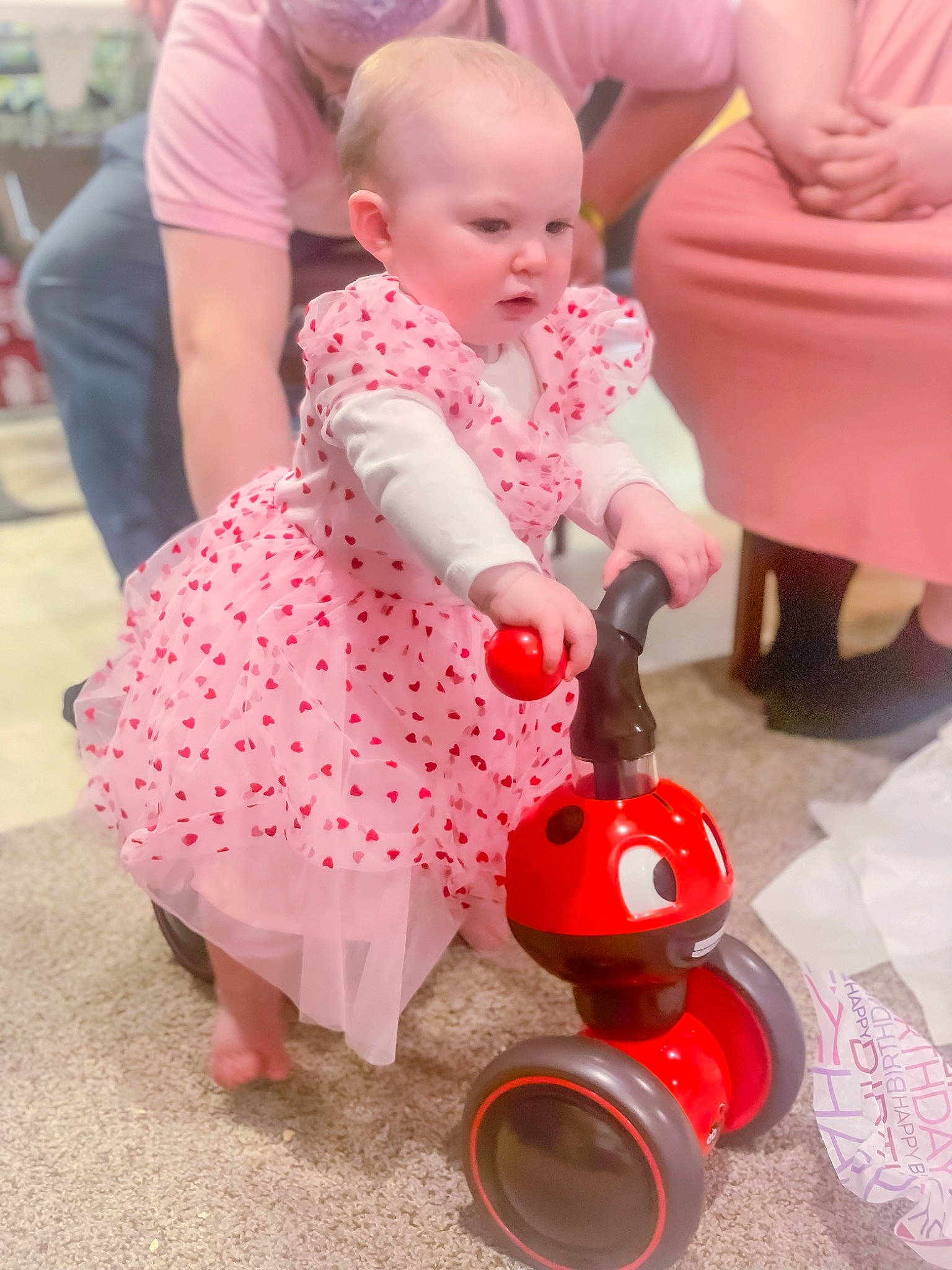 Jessica is registered to the contest to win money with this photo: baby, baby_products, baby_toddler_clothing, child, comfort, dress, event, face, flooring, fun, happy, lap, magenta, musical_instrument, person, pink, play, sandal, sitting, toddler