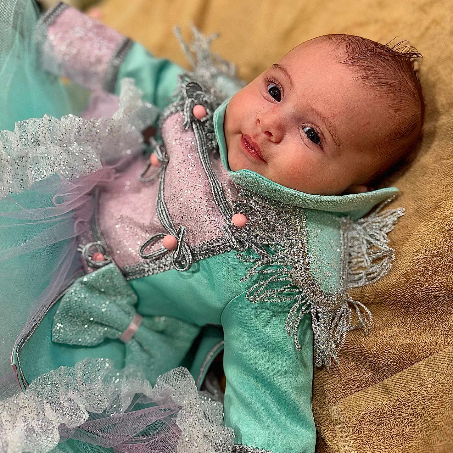 Adhara a rejoint le concours — aidez-le/la à gagner de superbes lots ! baby, child, clothing, costume, cute, decorative, eyes, fabric, face, infant, lying_down, pink, portrait, ruffles, smile, soft_texture, sparkle, towel, tulle, turquoise