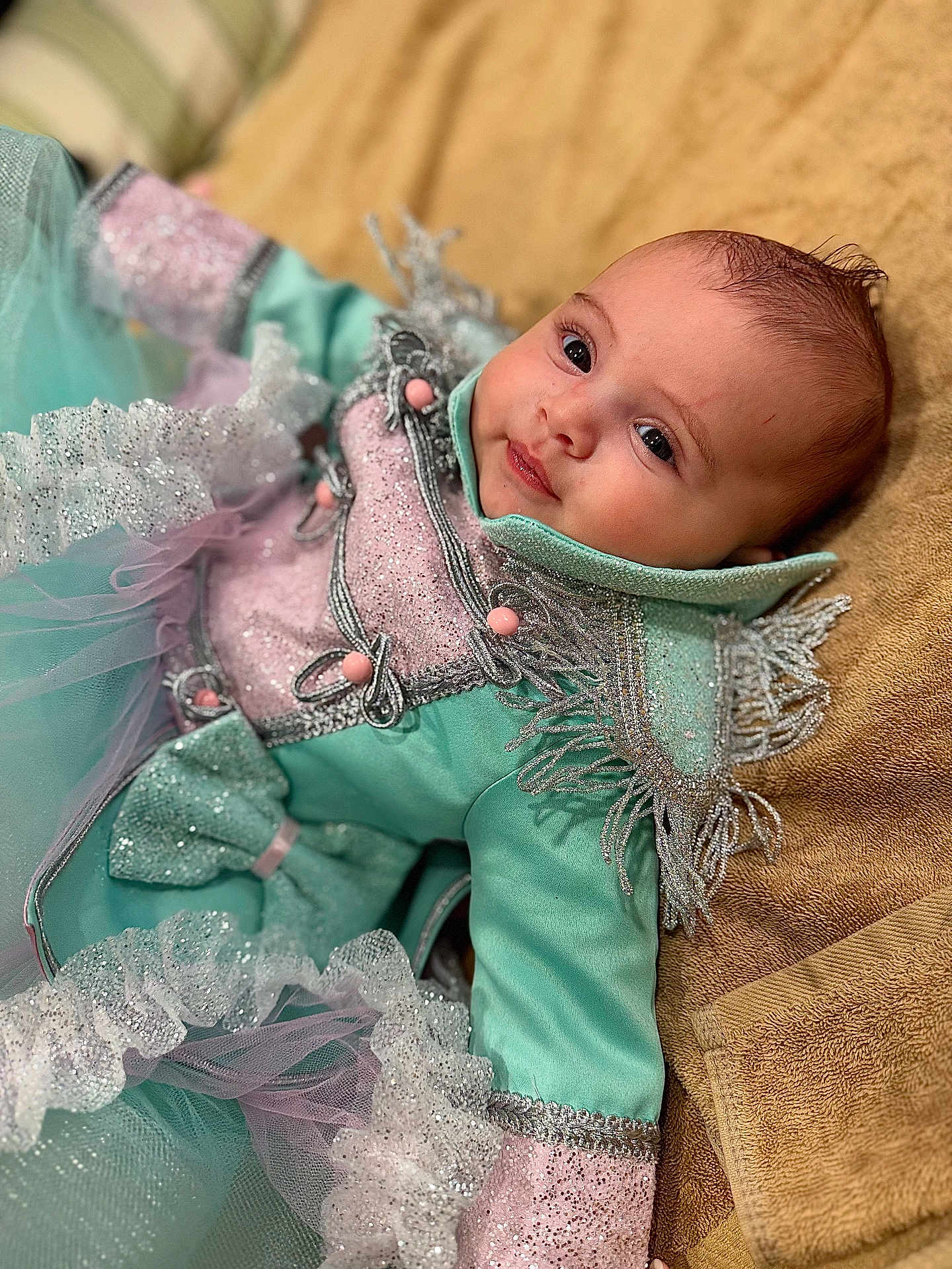 Adhara a rejoint le concours — aidez-le/la à gagner de superbes lots ! baby, infant, costume, sparkle, tulle, ruffles, turquoise, pink, face, eyes, towel, fabric, clothing, portrait, cute, lying_down, soft_texture, decorative, child, smile